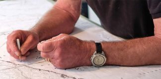 man's hands drawing a map