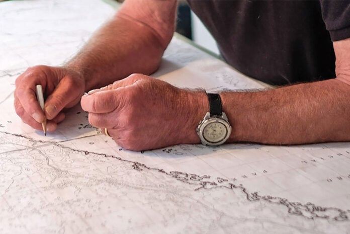 man's hands drawing a map