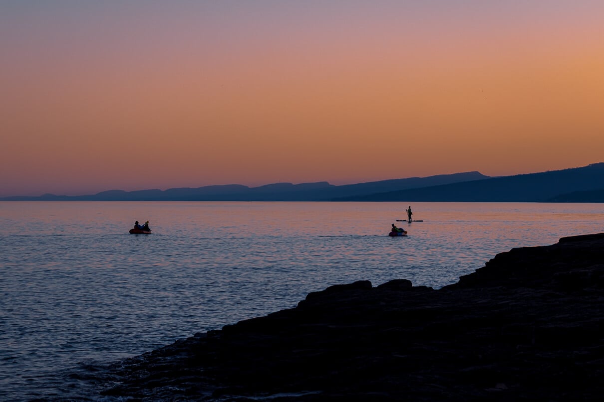 packrafters and paddleboarders on lake superior at sunset