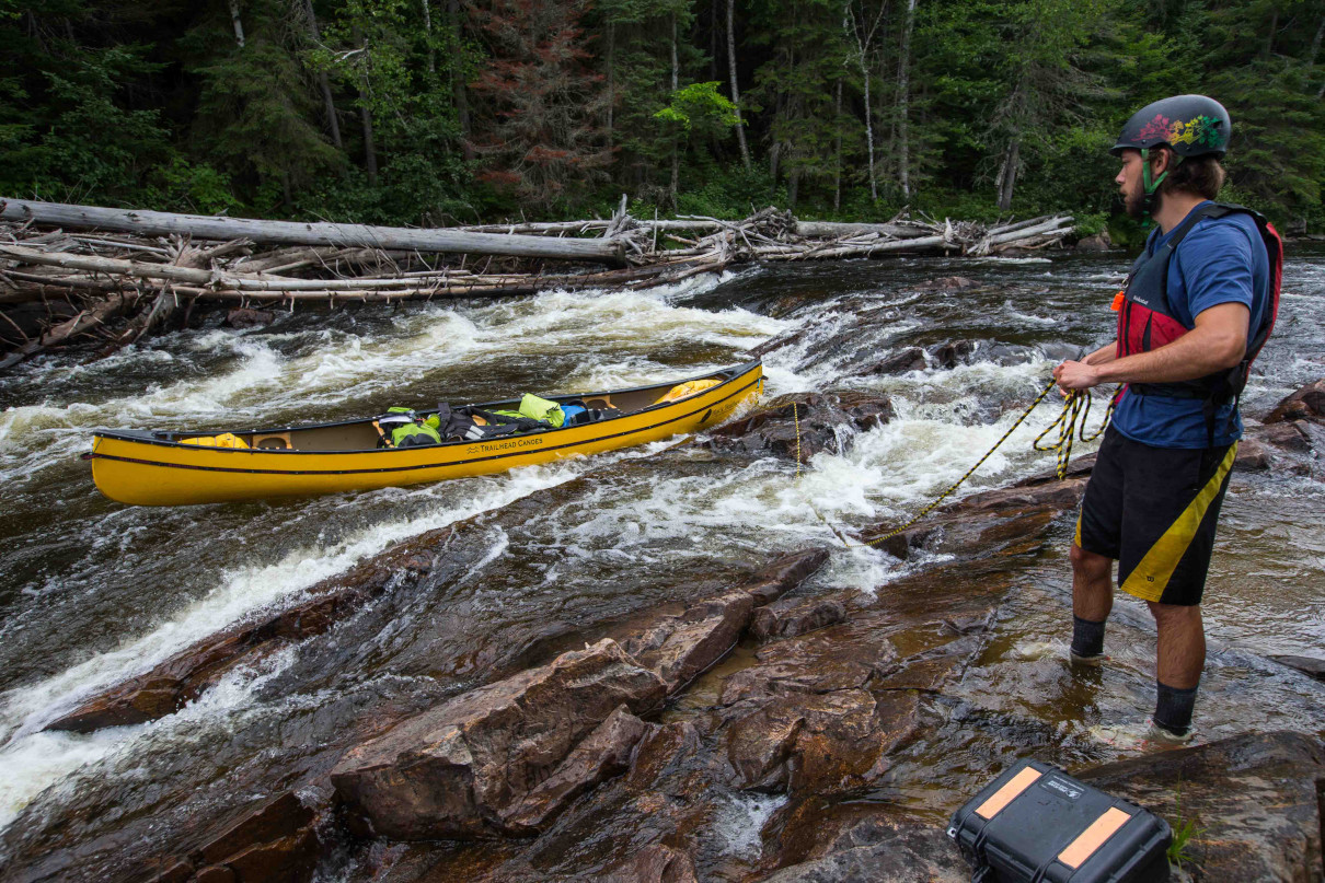 A good example of how to line a canoe through a rapid.