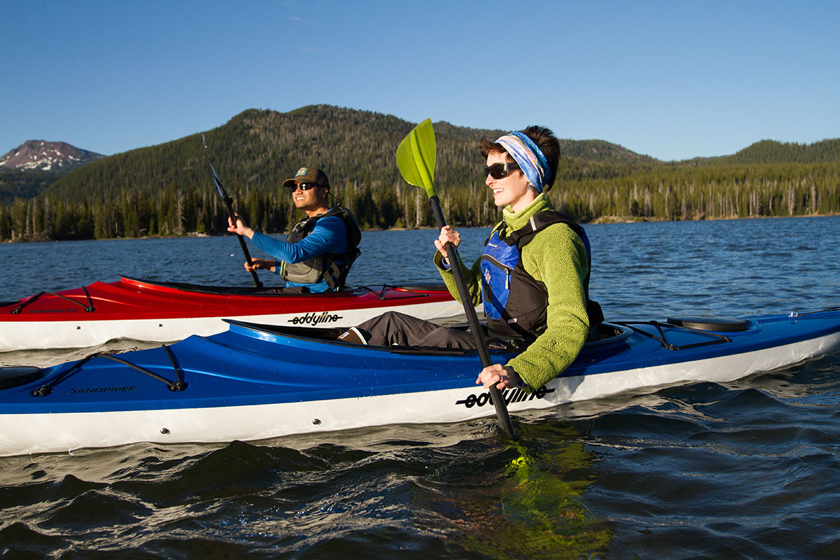 two people paddle sit-inside kayaks