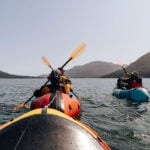Best Packrafts people packraft on expansive waters surrounded by hills