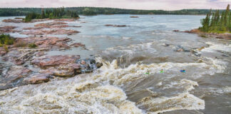 whitewater kayakers paddle into the Mountain Portage Rapids on the Slave River