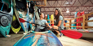 a salesman assists a woman purchasing a kayak