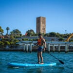 man stands and paddles a beginner paddleboard