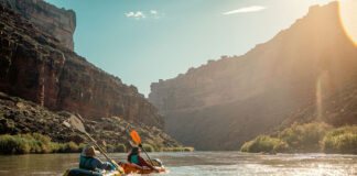 two packrafters paddle down the sunny San Juan River on trip