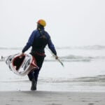 Best Current Designs Kayaks For 2026 man carries Current Designs Sisu kayak into the water on a beach