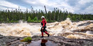 Benny Marr walks past a large rapid on the Nottoway River in Northern Canada