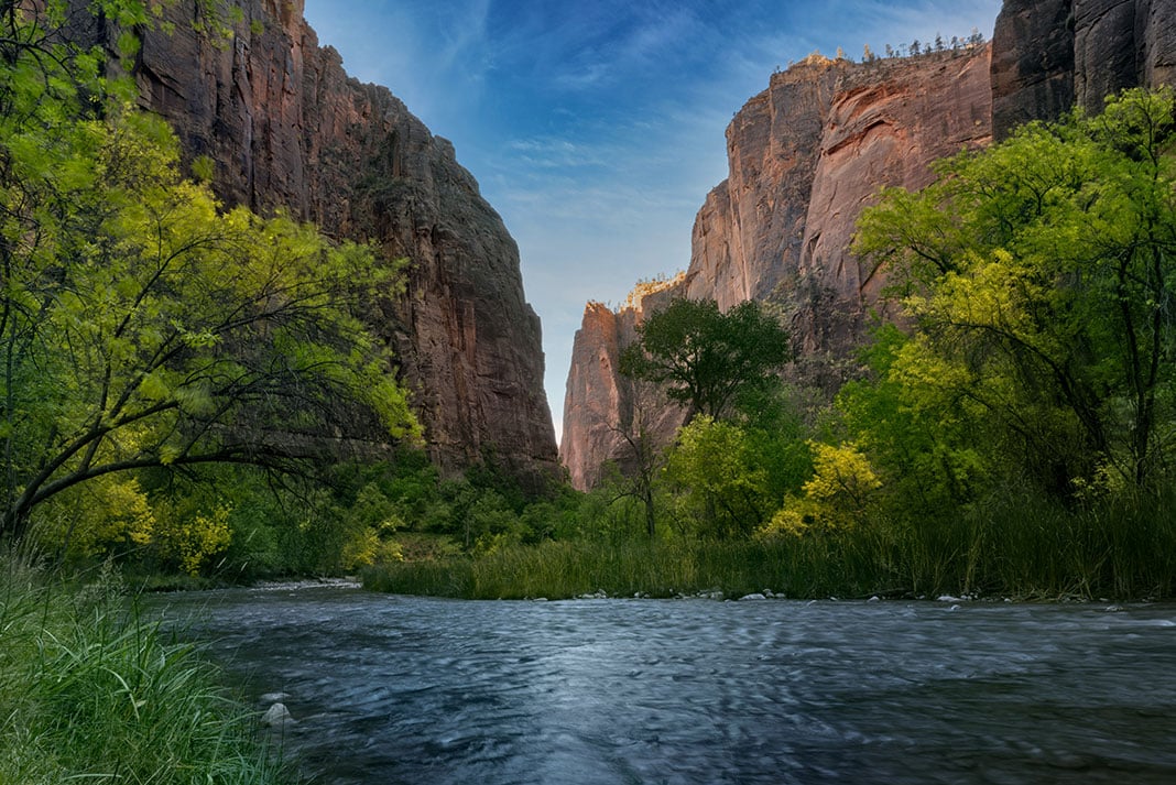 Utah's Green River runs between towering cliffs at sunrise