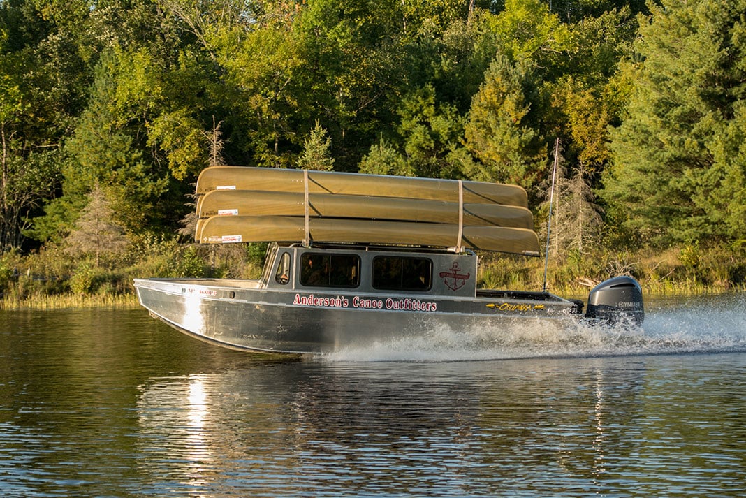 a group of canoes are lashed to the top of a water plane as it takes off