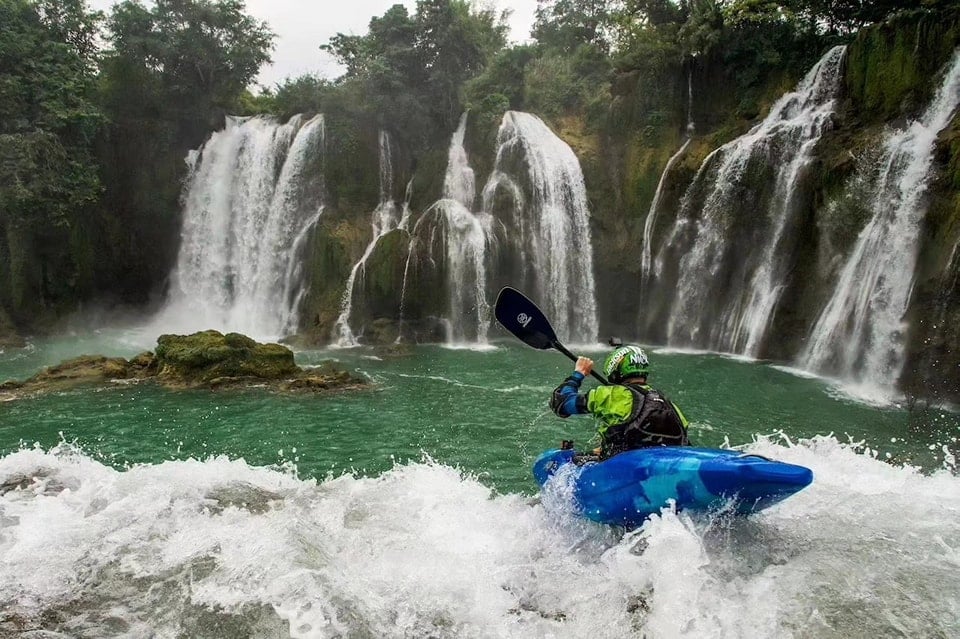 A Jackson Kayak paddler using a Werner Paddle as they go over a waterfall.