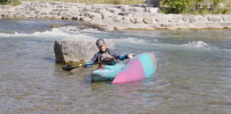 man demonstrates how to perform a kayak rescue in whitewater