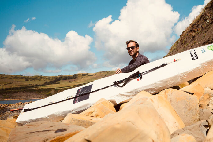 David Haze poses with his homemade standup paddleboard