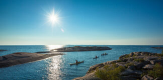 a family paddles in kayaks on a trip on Ontario's Georgian Bay