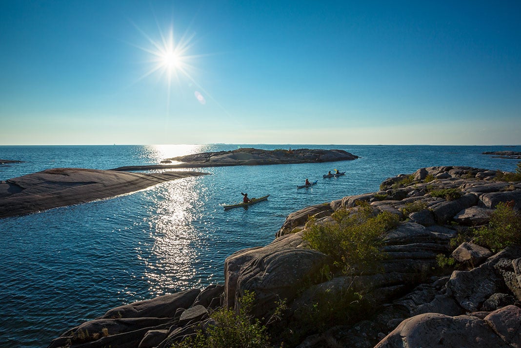 a family paddles in kayaks on a trip on Ontario's Georgian Bay