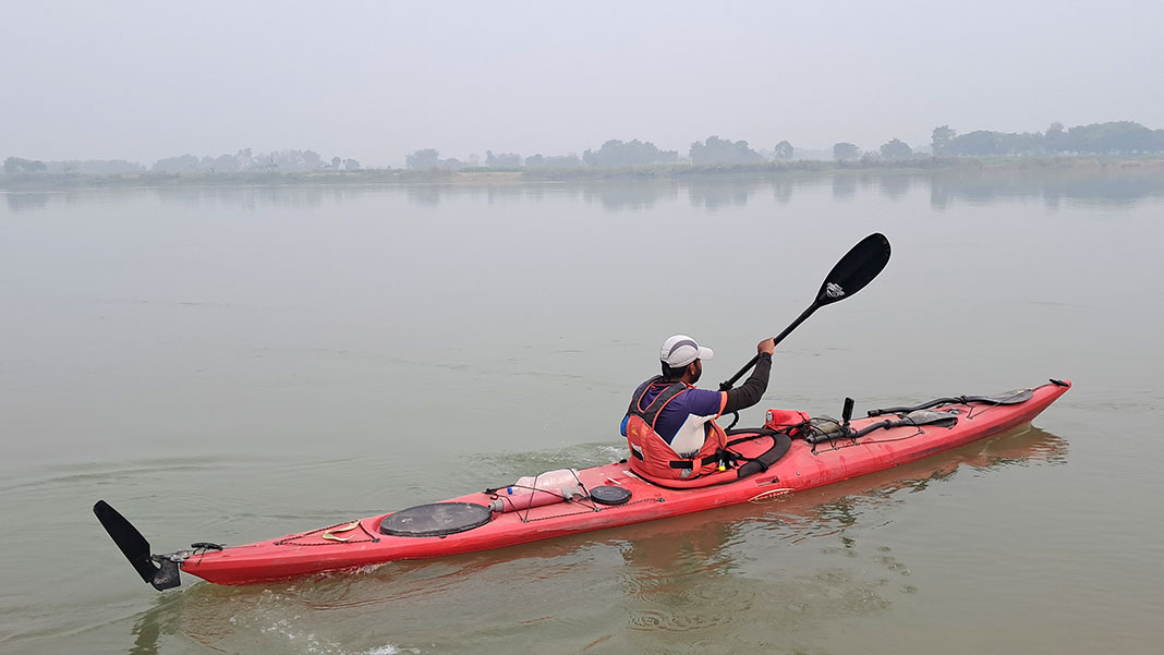 angler stands and casts in an Old Town Sportsman 106 fishing kayak powered by Minn Kota