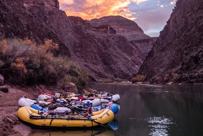 three whitewater rafts sit on the banks of a western river that requires a lottery system permit to paddle