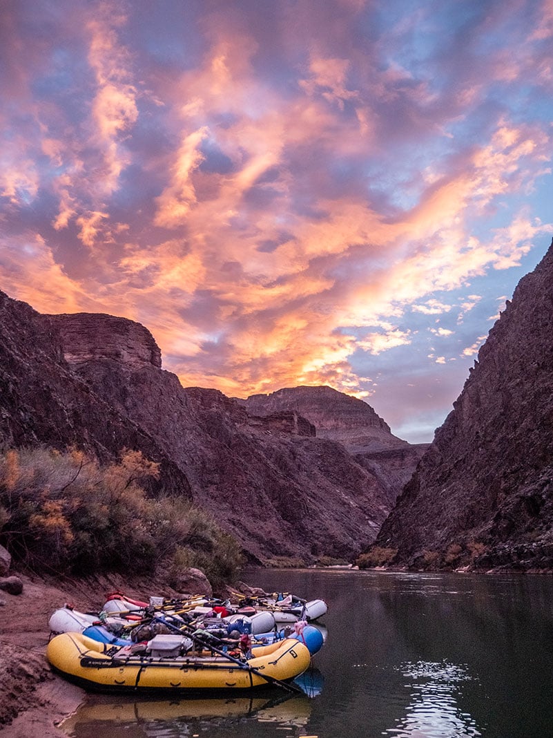 three whitewater rafts sit on the banks of a western river that requires a lottery system permit to paddle