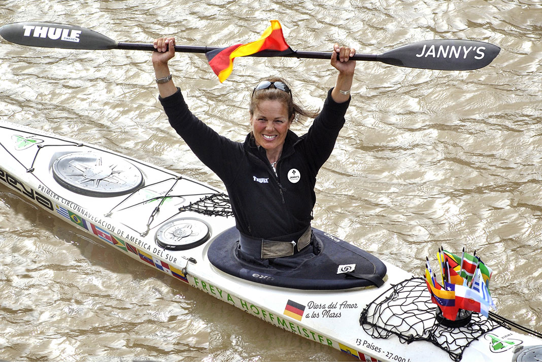 Freya Hoffmeister poses with paddle in the air after paddling around South America