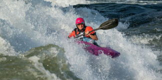 a person whitewater kayaking in a Jackson kayak with a Werner paddle