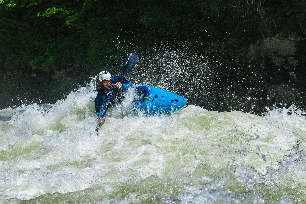 a whitewater kayaker paddles through rapids after satisfying the pre-run superstitions he observes