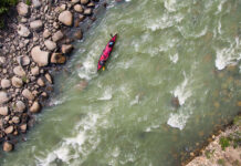 overhead view of a tandem paddling expedition boat travelling down a river