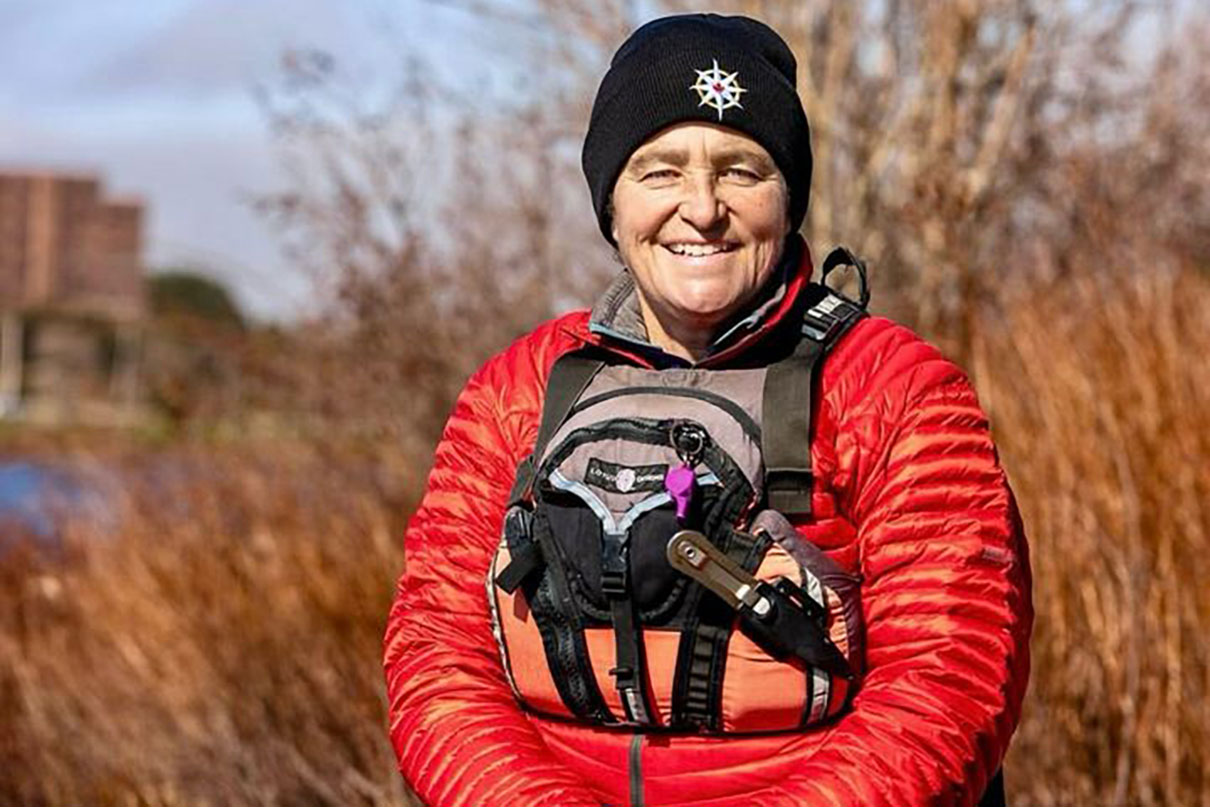 person poses in puffy jacket and PFD