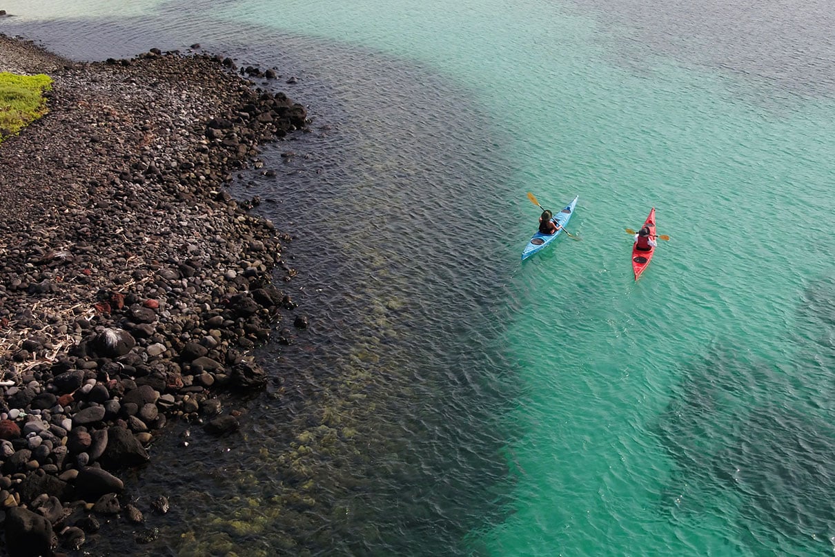 two people paddle sea kayaks in the turquoise waters of Baja, Mexico