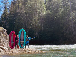 two women kayakers pose by the water with AIRE's Spud and Tater inflatable whitewater kayaks