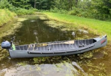 radisson canoe sits crosswise on narrow waterway with motor on stern