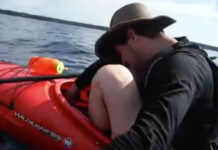 image of kayaker peering into boat after kayaker finds mouse in kayak while paddling the Bruce Peninsula, Ontario