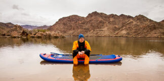 Paddlesports industry member Ryan Lightfoot sits in drysuit on an inflatable SUP on the Colorado River