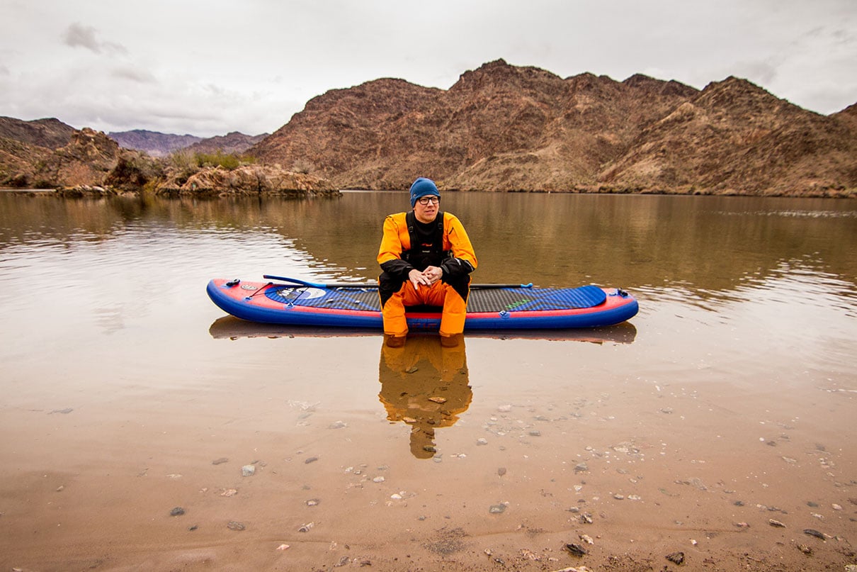 Paddlesports industry member Ryan Lightfoot sits in drysuit on an inflatable SUP on the Colorado River