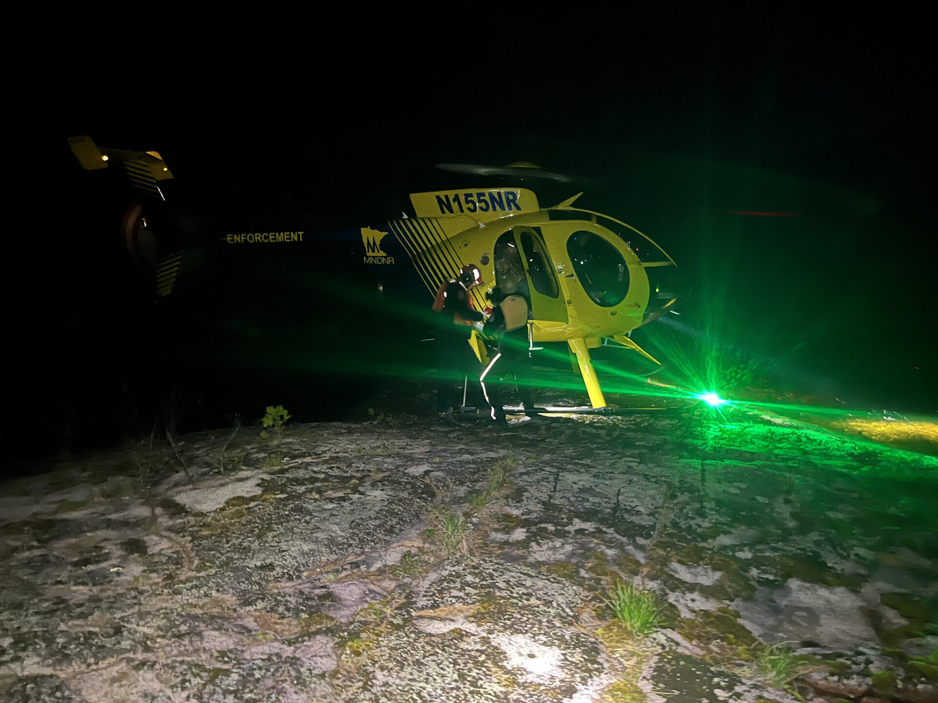 image of Grace Zeller's helicopter landing on a rock shelf in the dark in the Boundary Waters Canoe Area Wilderness courtesy of Tony Maynard, a bystander on scene of the canoe rescue in the BWCAW