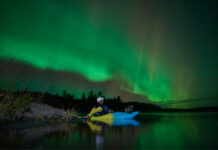 The Northern Lights on the Ottawa River over whitewater kayaker Joel Kowalski