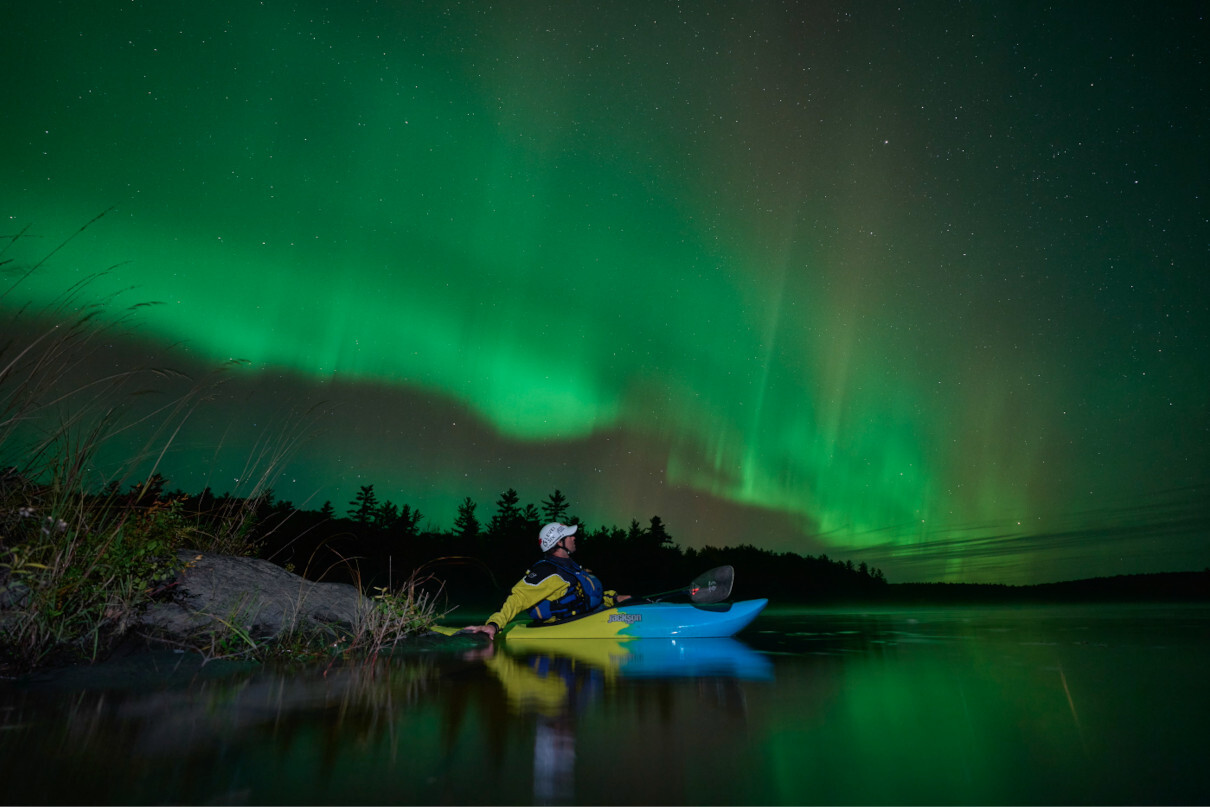 The Northern Lights on the Ottawa River over whitewater kayaker Joel Kowalski