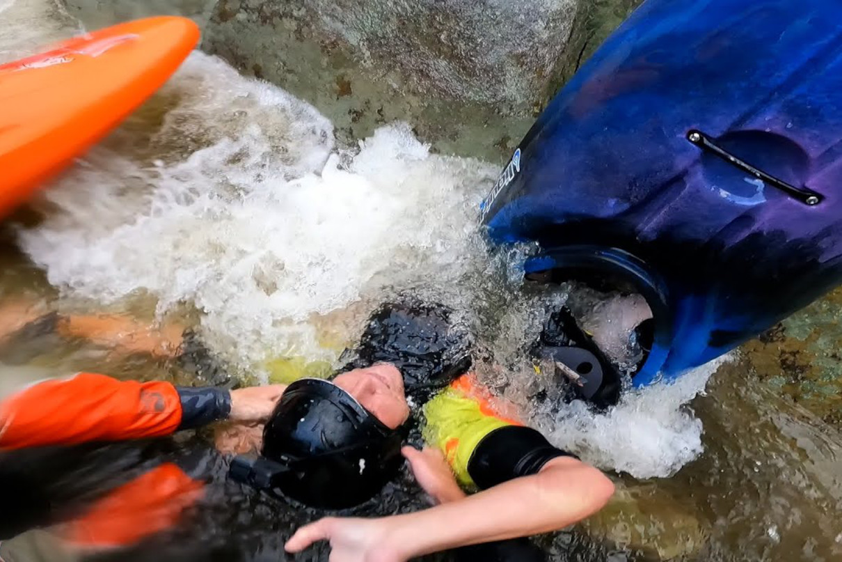 Whitewater kayaker being pulled out of a sieve during rescue on Linville River.