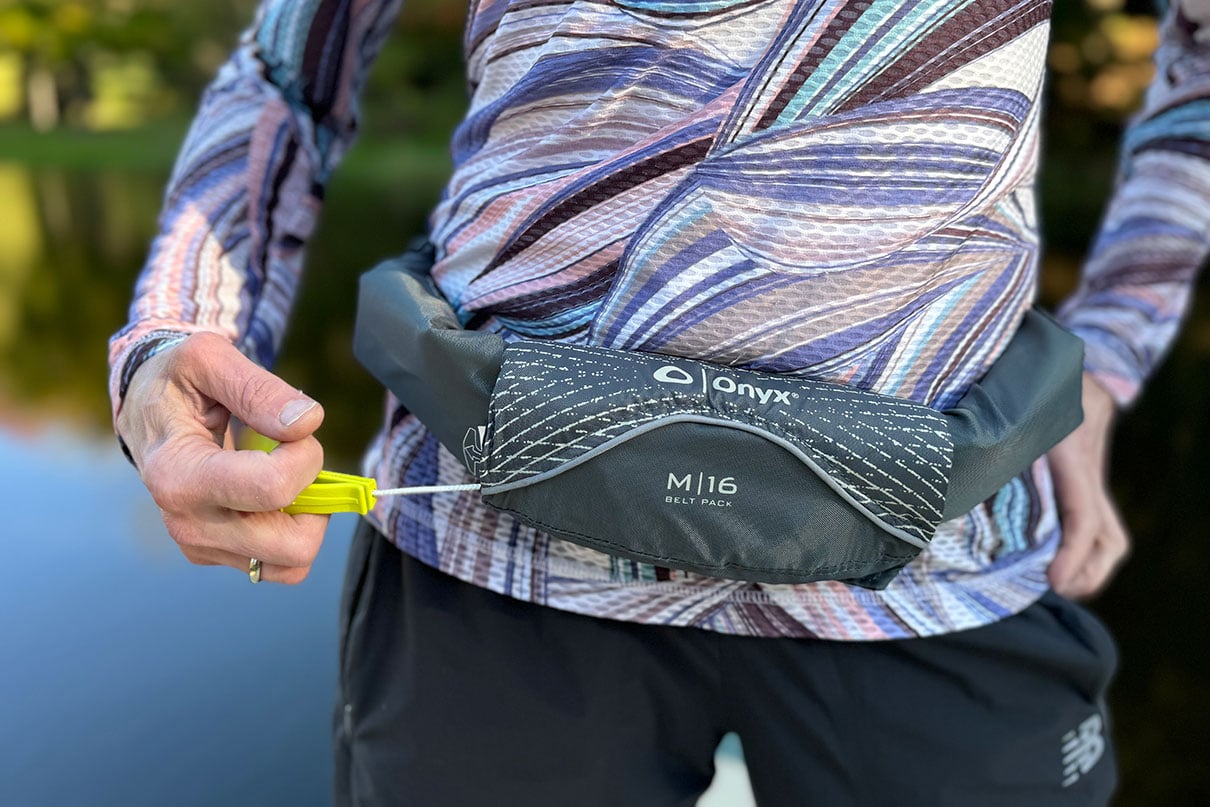 person poses while wearing the ONYX M16 inflatable belt PFD