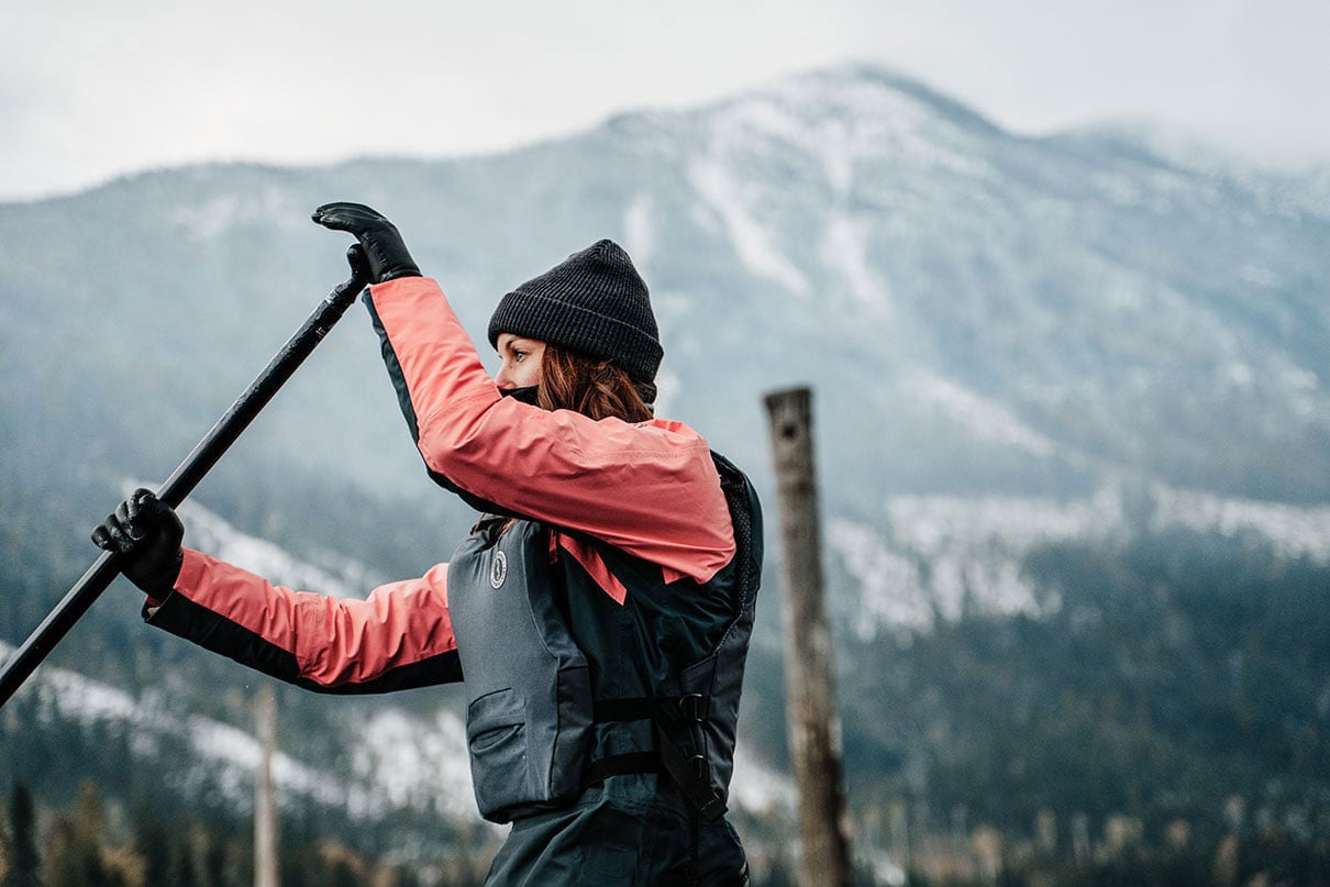 woman paddles in winter while wearing the Mustang Khimera PFD