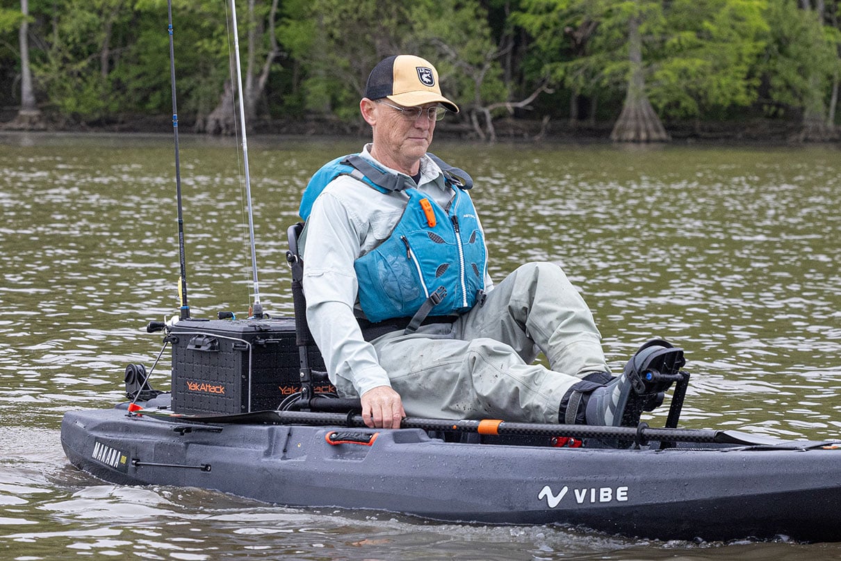 Ric Burnley pedals a fishing kayak while wearing the Astra EV-Eight life jacket