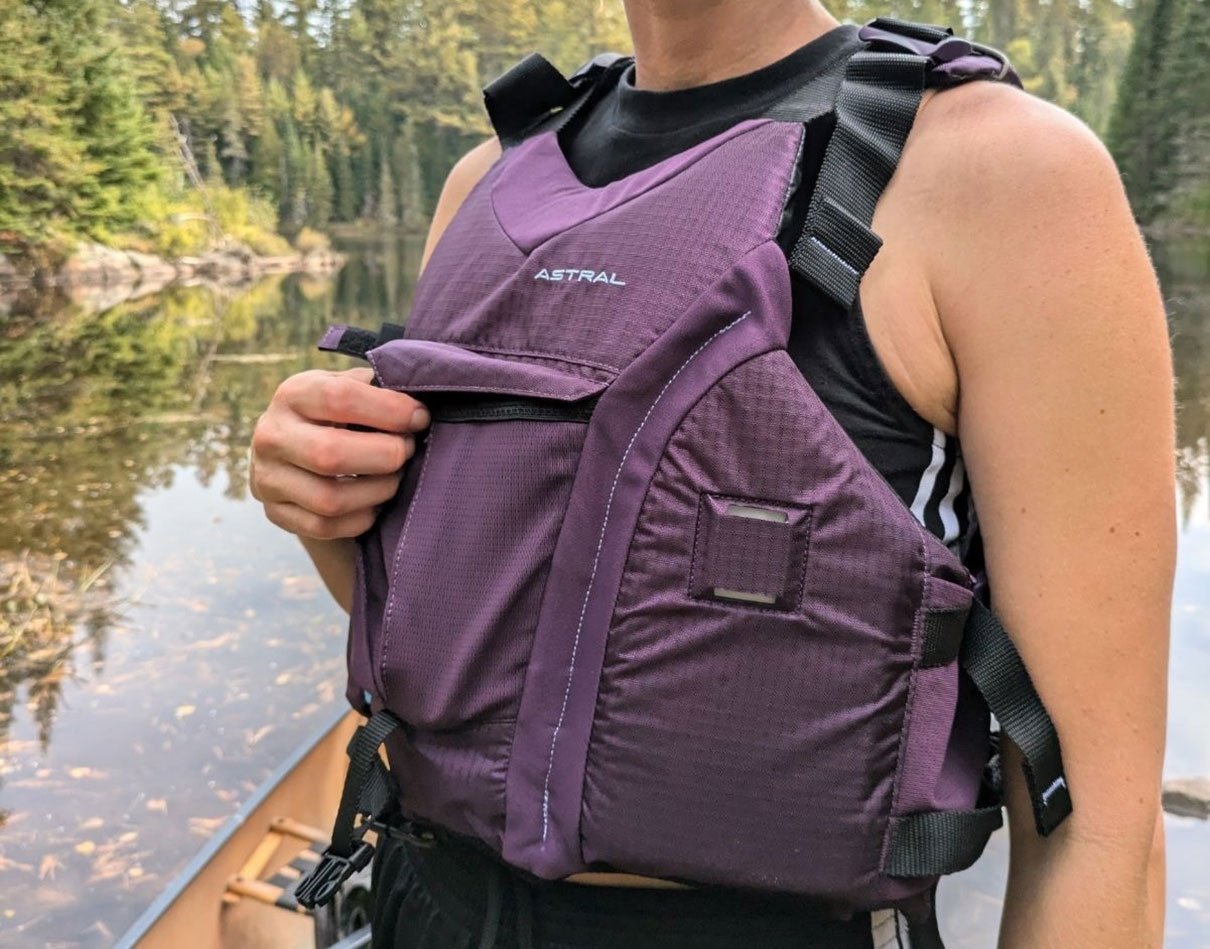 woman wears the Astral Layla life jacket by riverside