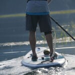 Best SUP Paddles For 2025 man paddles his paddleboard