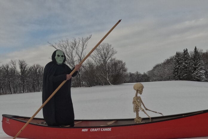 Halloween costume dress up in a canoe on a frozen river