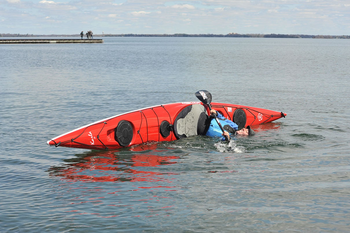 woman smiles while performing a roll in the Current Designs Karla touring kayak