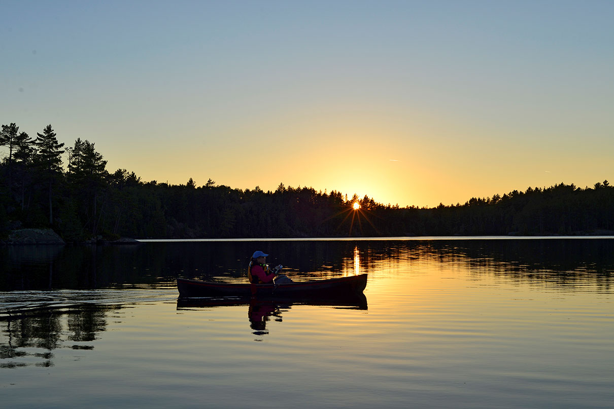 person canoeing at dawn