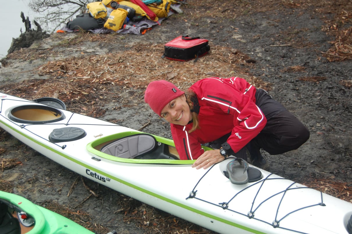 Kayaker checking their foot braces before launching.