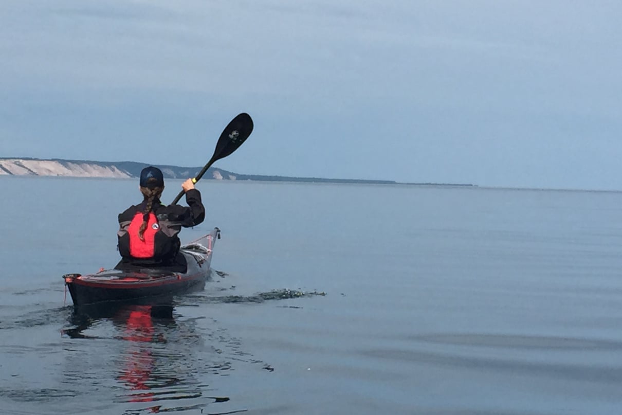 Kayaker paddling across open water.