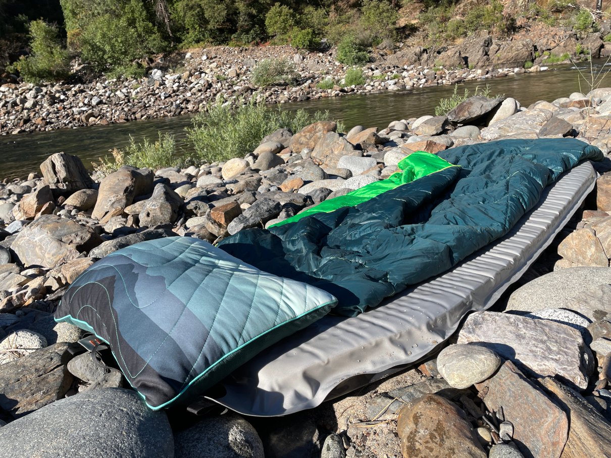 Camp sleep setup on rocky beach.