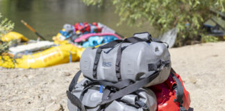 stack of NRS DriDuffels on sandy beach