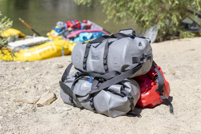 stack of NRS DriDuffels on sandy beach